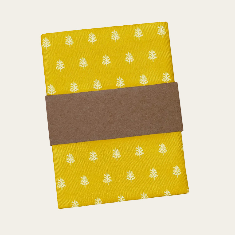 Yellow fabric pocket square with white tree pattern and brown band on a white background