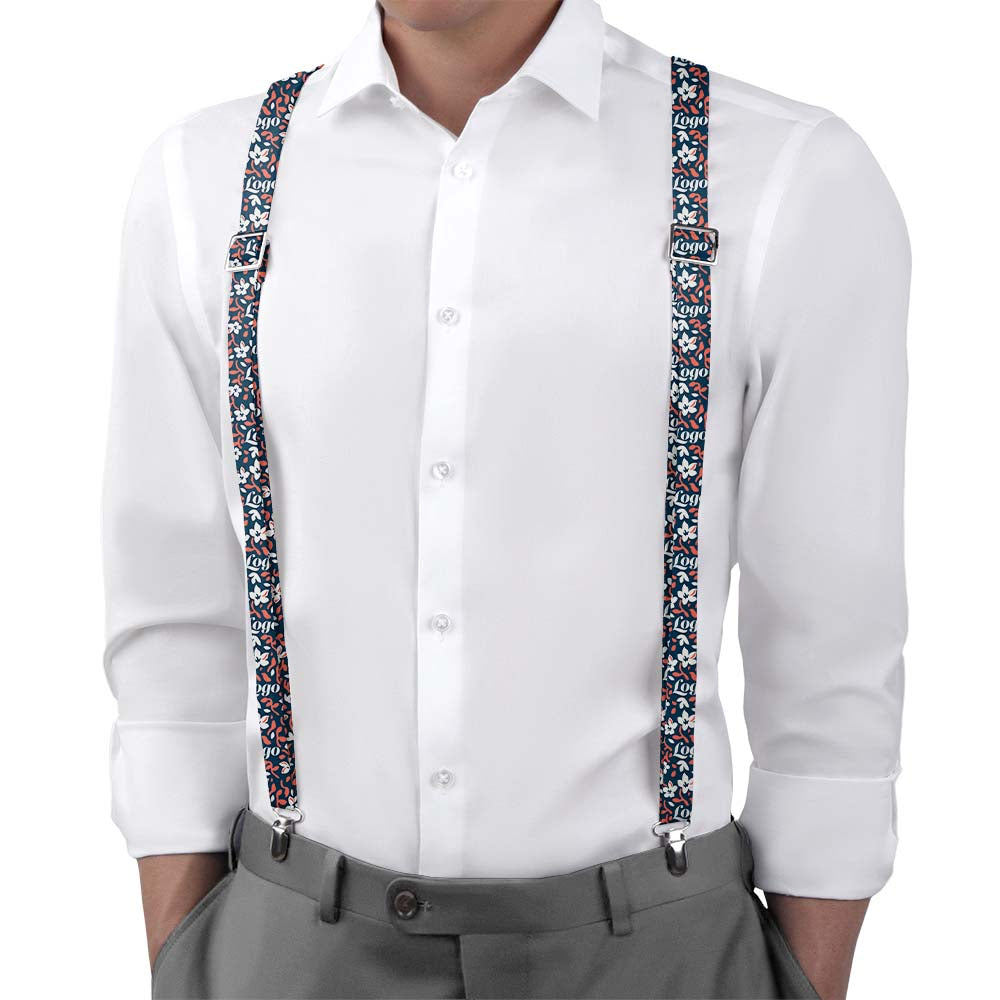 Person wearing a white shirt with floral-patterned logo suspenders and gray pants on a white background