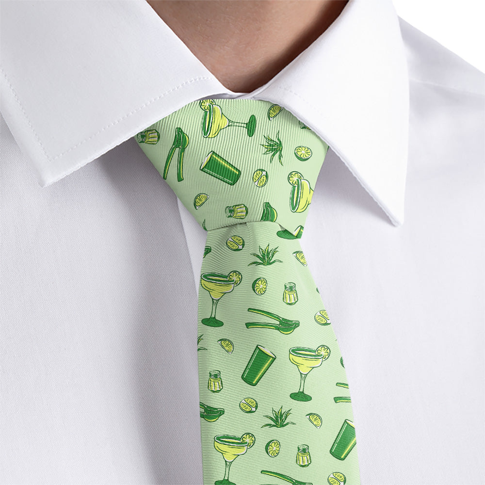 Green tie with cocktail pattern worn by a person in a white shirt