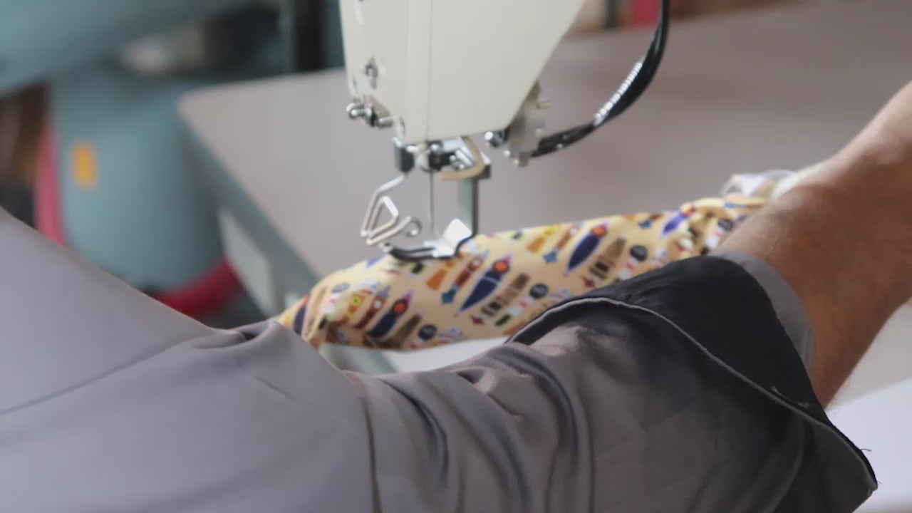 Load video: Custom Ties being manufactured and knotty logo tag being sewn onto the back