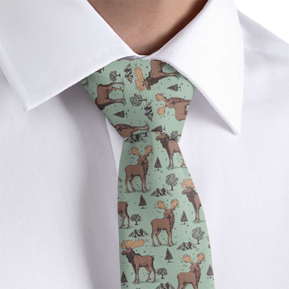 Tie with moose pattern worn by a person in a white shirt