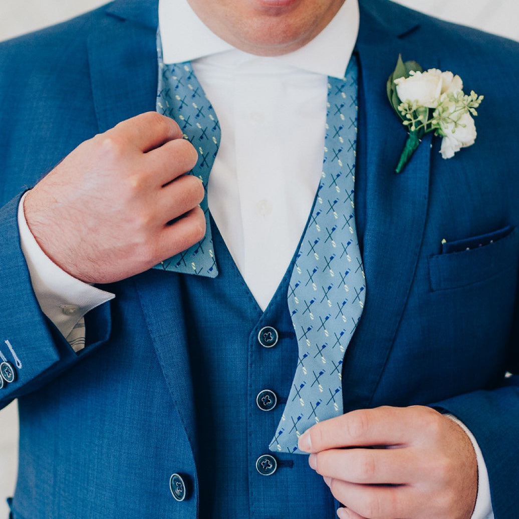 man putting on a blue bow tie