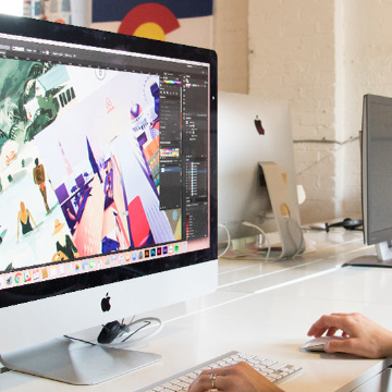 Person using a computer with a colorful design on the screen in an office setting