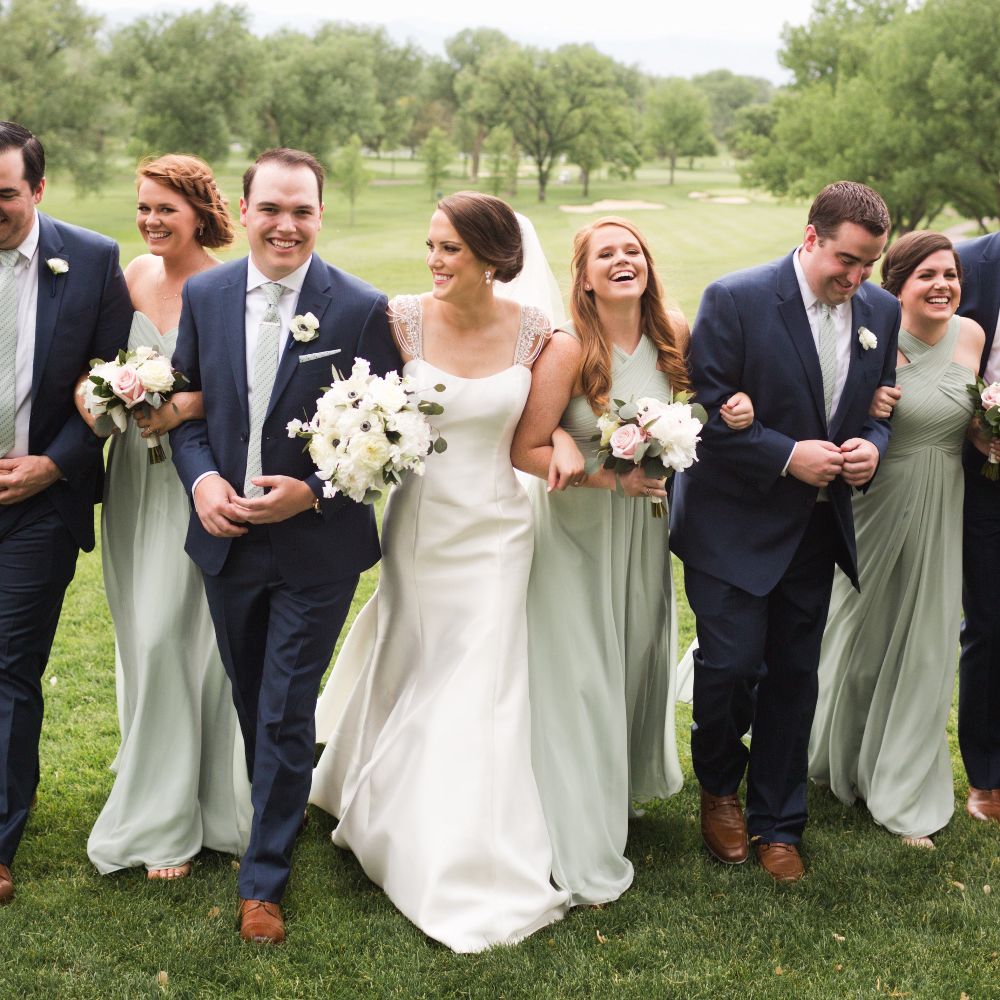 bridal party in coordinated outfits linking arms