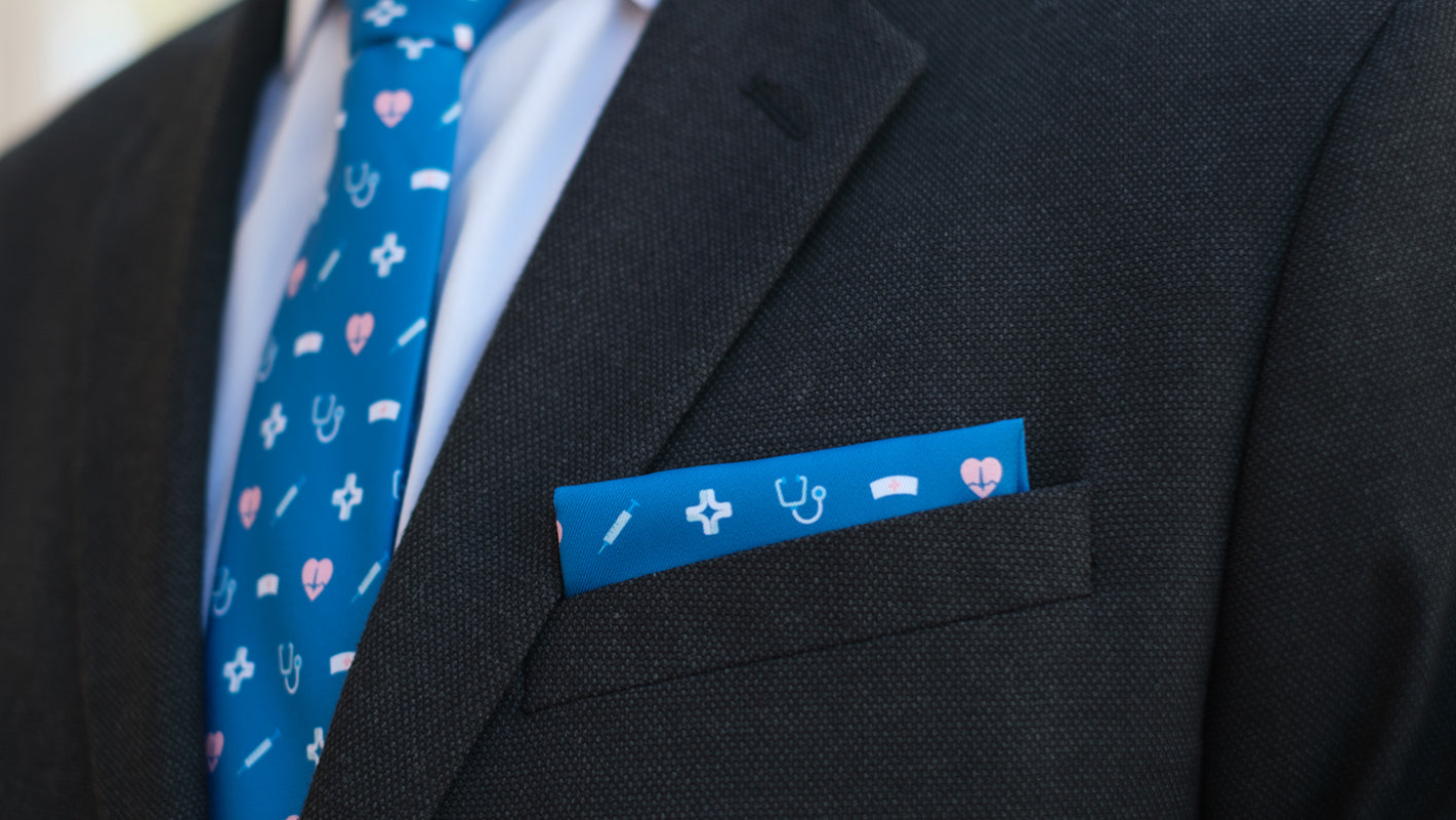 close up of a custom medical branded pocket square in the pocket of a blue suit jacket
