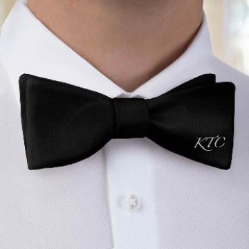 Black bow tie with 'KTC' monogram on a white shirt